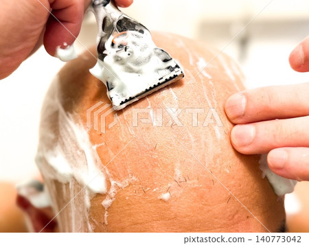 A middle-aged man with a shaved head. A middle-aged man with a shaved head. 140773042