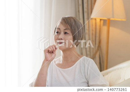 Senior woman brushing teeth 140773261
