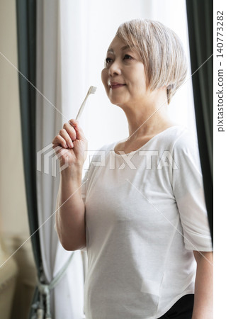 Senior woman brushing teeth 140773282