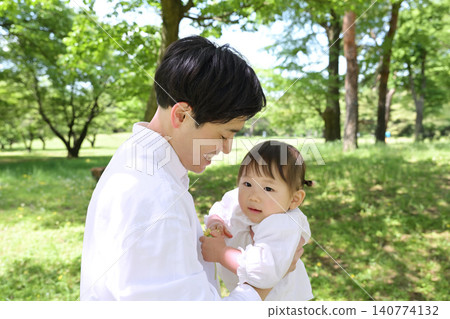A young father holding his beloved daughter in his arms. A young father holding his beloved daughter in his arms. 140774132