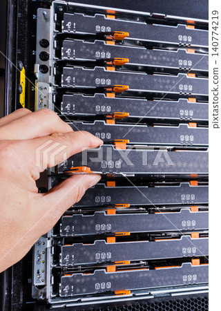 network administrator pulling data storage hardware from sever r 140774219