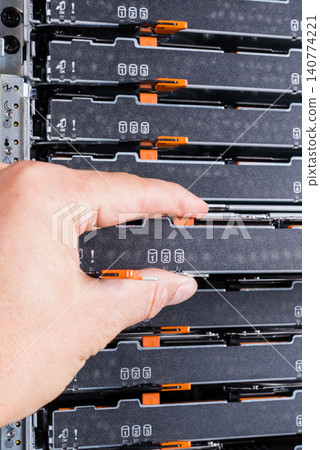 network administrator pulling data storage hardware from sever r 140774221