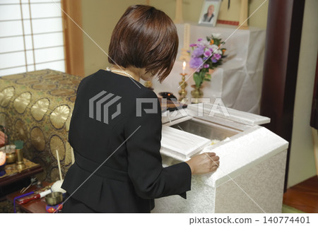 A woman mourns the passing of the deceased at a funeral. A woman mourns the passing of the deceased at a funeral. 140774401