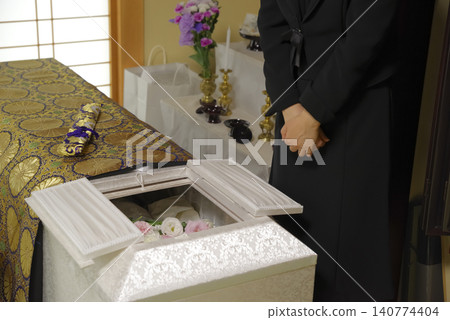 A woman mourns the passing of the deceased at a funeral. A woman mourns the passing of the deceased at a funeral. 140774404