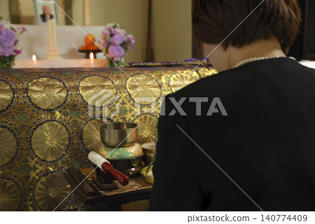 一位婦女在葬禮上悼念逝者。 一位婦女在葬禮上悼念逝者。 140774409