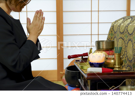 A woman mourns the passing of the deceased at a funeral. A woman mourns the passing of the deceased at a funeral. 140774413