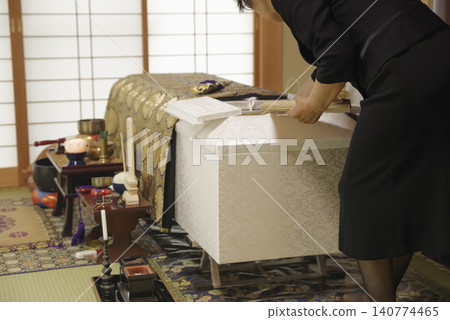 A woman mourns the passing of the deceased at a funeral. A woman mourns the passing of the deceased at a funeral. 140774465