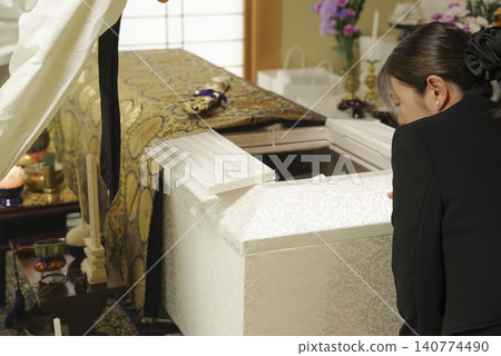 一位婦女在葬禮上悼念逝者。 一位婦女在葬禮上悼念逝者。 140774490