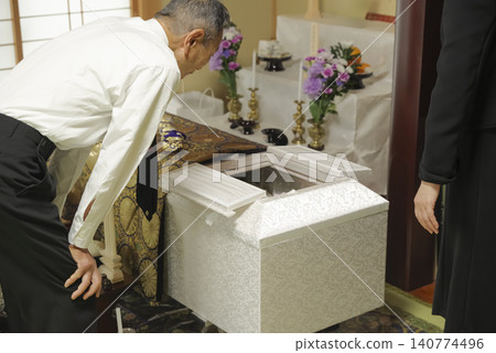 Family members mourn the passing of their loved one at the funeral. Family members mourn the passing of their loved one at the funeral. 140774496