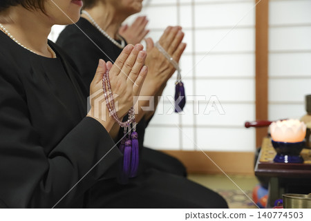 家屬手持念珠,為逝者祈禱。 家屬手持念珠,為逝者祈禱。 140774503