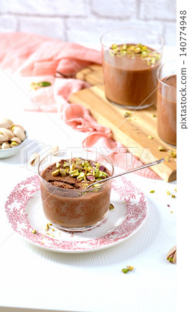 A chocolate mousse dessert topped with pistachios in a vertical format A chocolate mousse dessert topped with pistachios in a vertical format 140774948