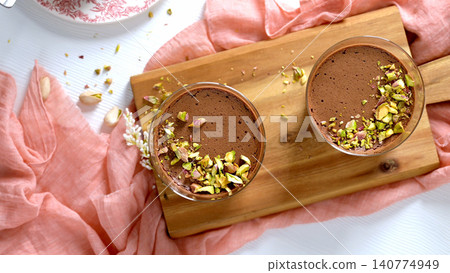 An overhead view of two chocolate mousse desserts on a wooden board An overhead view of two chocolate mousse desserts on a wooden board 140774949