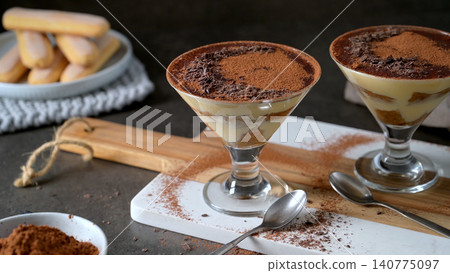 Elegant Tiramisu Dessert Served in stemmed cocktail Glasses with Cocoa Powder and Ladyfingers Elegant Tiramisu Dessert Served in stemmed cocktail Glasses with Cocoa Powder and Ladyfingers 140775097