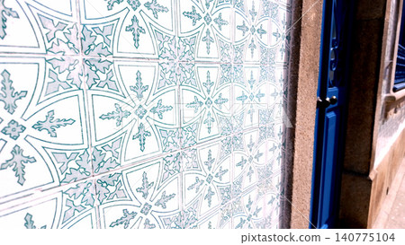 Traditional Portuguese Azulejo Tiles on Exterior Wall with Blue Door Traditional Portuguese Azulejo Tiles on Exterior Wall with Blue Door 140775104