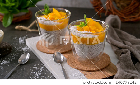 Chia Seed Pudding with Mango and Shredded Coconut in Glass Jars 140775142