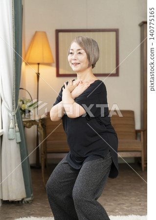Senior woman stretching in the living room 140775165