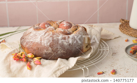 Traditional Portuguese Easter Sweet Bread Folar de Pascoa with Red Eggs on a White Wire Rack Traditional Portuguese Easter Sweet Bread Folar de Pascoa with Red Eggs on a White Wire Rack 140775177