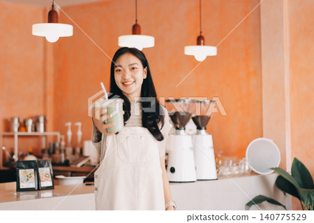 Young woman drinking iced coffee outside a chocolate shop Young woman drinking iced coffee outside a chocolate shop 140775529