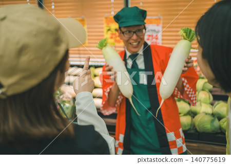 Customer and store clerk wearing a happi coat communicate during a limited-time sale. 140775619