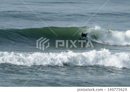 Bodyboarder riding a wave Bodyboarder riding a wave 140775629