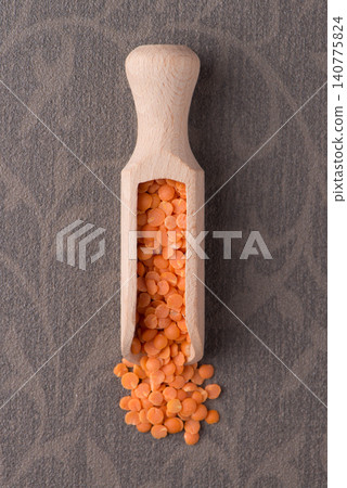 Wooden scoop with peeled lentils Wooden scoop with peeled lentils 140775824