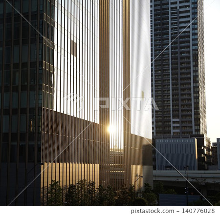 The glass windows of a skyscraper reflecting the setting sun The glass windows of a skyscraper reflecting the setting sun 140776028