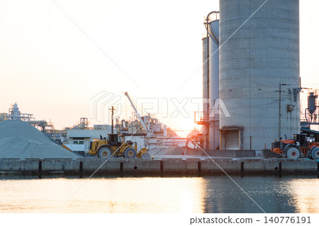 The port and silos of the Takasago Industrial Zone, bathed in the setting sun (Takasago City, Hyogo Prefecture) 140776191