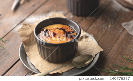 Homemade creme brulee dessert with caramelized sugar crust in a black ramekin Homemade creme brulee dessert with caramelized sugar crust in a black ramekin 140776227