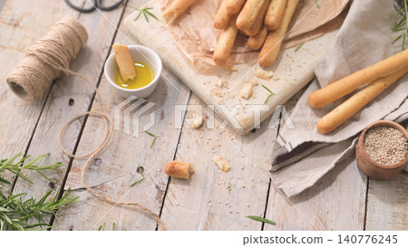 Rustic Italian grissini breadsticks with olive oil and rosemary Rustic Italian grissini breadsticks with olive oil and rosemary 140776245