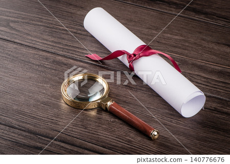 Wrapped paper sheets and magnifying glass Wrapped paper sheets and magnifying glass 140776676