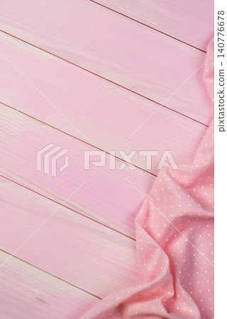 Pink towel over wooden table Pink towel over wooden table 140776678