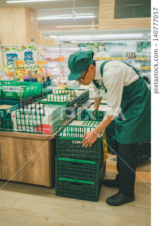Employees working in the vegetable section of a supermarket. 140777057