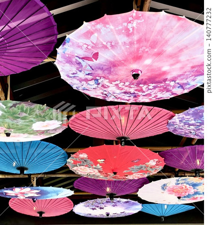 A variety of brightly colored and colorful Japanese umbrellas decorate the ceiling of the roof. A variety of brightly colored and colorful Japanese umbrellas decorate the ceiling of the roof. 140777232