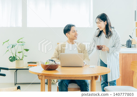 看一台計算機的年輕夫婦在客廳 140777803