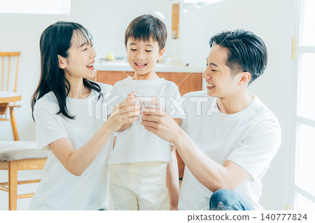 年輕家庭在客廳喝水 140777824