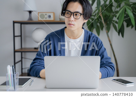A man who operates a personal computer at home A man who operates a personal computer at home 140778410