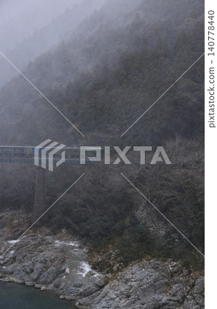 Snow is approaching from the north as the No. 2 Yoshino River Bridge in the Oboke Gorge passes over it by JR Shikoku's sightseeing train, "Shikoku Mannaka Sennen Monogatari". Snow is approaching from the north as the No. 2 Yoshino River Bridge in the Oboke Gorge passes over it by JR Shikoku's sightseeing train, "Shikoku Mannaka Sennen Monogatari". 140778440