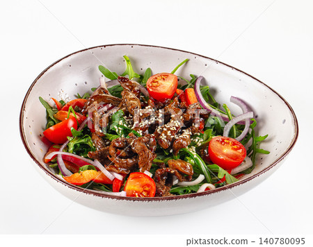 Asian style beef salad with arugula cherry tomatoes red onion and sesame seeds in ceramic bowl Asian style beef salad with arugula cherry tomatoes red onion and sesame seeds in ceramic bowl 140780095