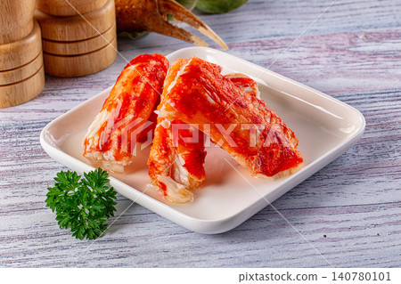 Crab legs on white plate with parsley garnish and wooden salt shakers Crab legs on white plate with parsley garnish and wooden salt shakers 140780101