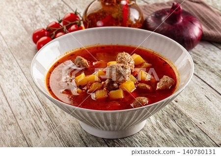 Bowl of hearty meatball soup with potatoes and tomato broth on rustic wood Bowl of hearty meatball soup with potatoes and tomato broth on rustic wood 140780131