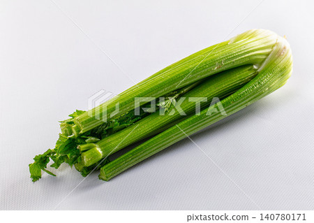 Fresh celery stalks on white textured background Fresh celery stalks on white textured background 140780171
