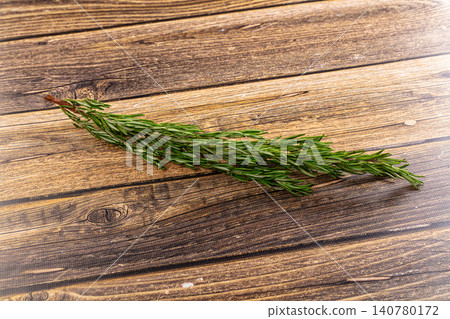 Fresh rosemary sprig on rustic wooden surface Fresh rosemary sprig on rustic wooden surface 140780172