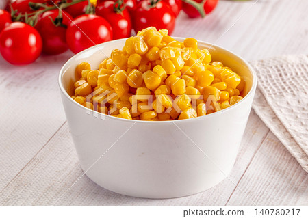 Bowl of fresh corn kernels with cherry tomatoes on wooden table 140780217