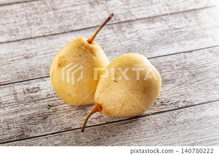 Two ripe yellow pears on rustic wooden surface Two ripe yellow pears on rustic wooden surface 140780222