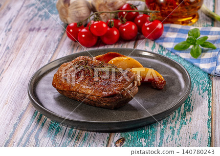 Roasted duck breast with rosemary and peach on rustic plate Roasted duck breast with rosemary and peach on rustic plate 140780243