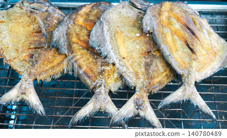Top view of delicious deep-fried whole pomfret fishes, traditional Asian seafood menu background. 140780489