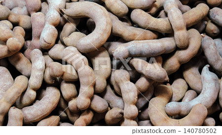 Close-up of fresh sweet tamarind pods, full frame background of brown tamarind texture. 140780502