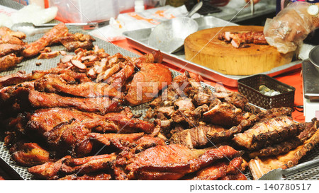 Chef chopping honey-glazed barbecued pork on a wooden cutting board at an authentic Thai-Chinese restaurant stall. Chef chopping honey-glazed barbecued pork on a wooden cutting board at an authentic Thai-Chinese restaurant stall. 140780517