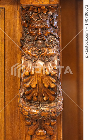 Green man wood carving decorating oak furniture detail Green man wood carving decorating oak furniture detail 140780672