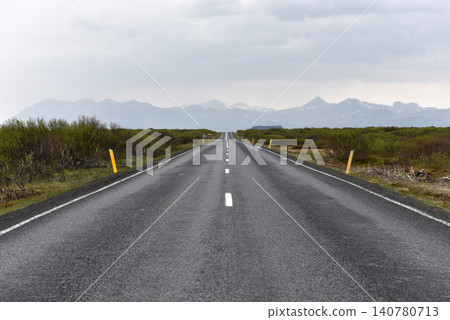 Scenic empty highway leading toward Icelandic mountains 140780713